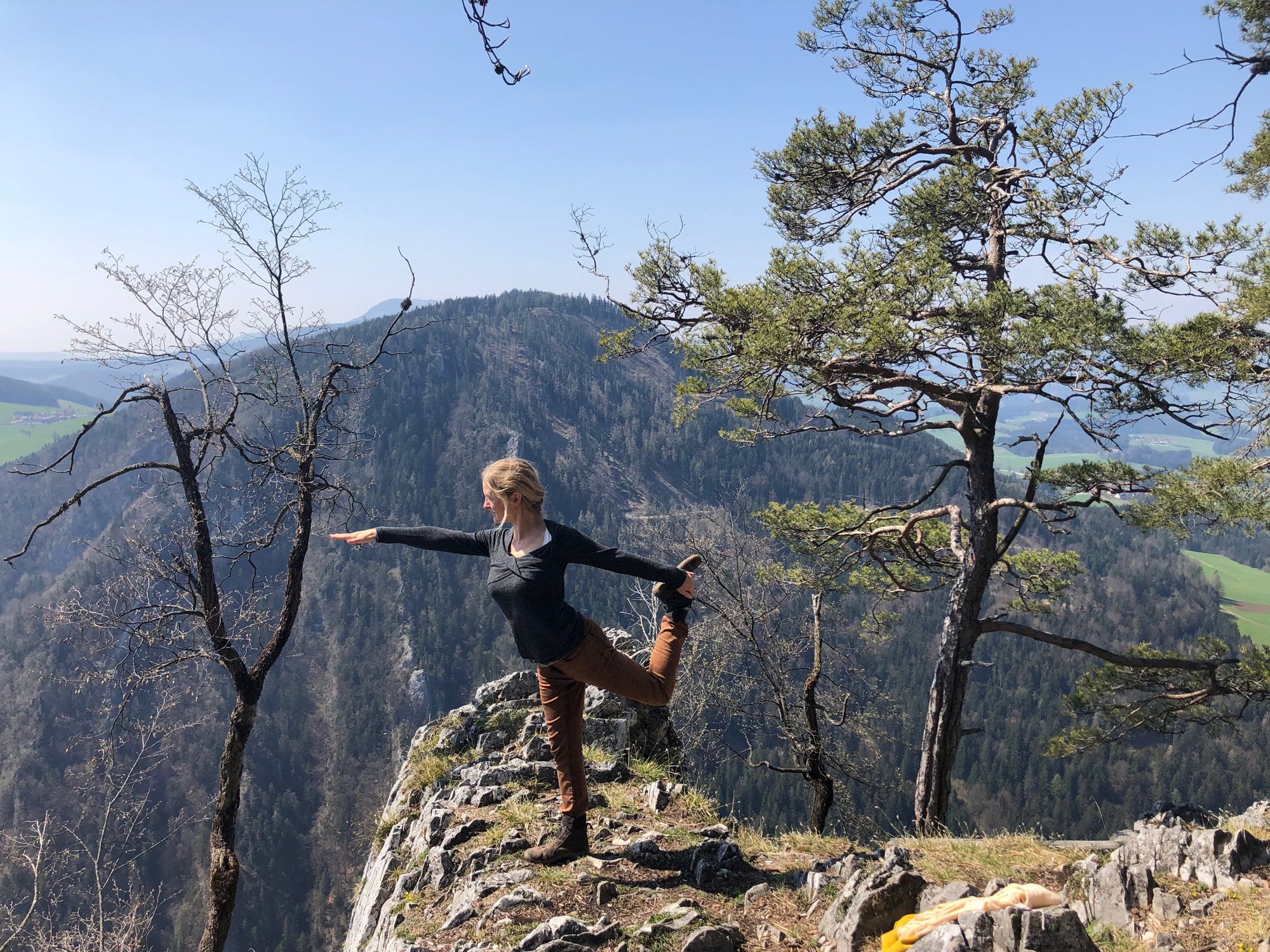 Christina Pucher in einer Yoga-Haltung auf einem Bergfelsen